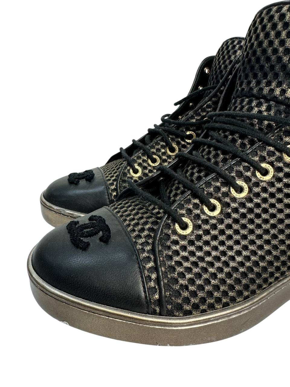 Black high-top sneakers with glossy finish and gold mesh detailing